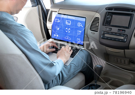 Mechanic using laptop computer to check during work a car engine on car at repair garage. focus finger hand. 78196940