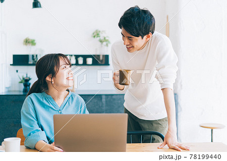 一緒にパソコンを見る若い夫婦 カップル 78199440