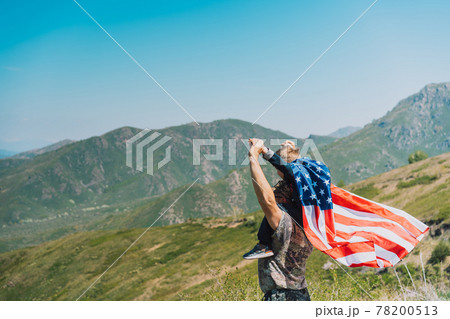 Man and child celebrate fourth of july with american flag in nature 78200513