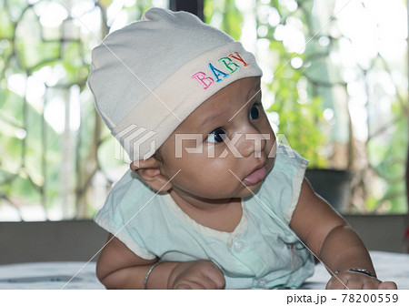 Cute baby hold his head up. Closeup portrait. Happy baby boy smiling looking away. Health care medical background. Sweet little infant toddler. Indian ethnicity. Developmental milestone for baby. 78200559