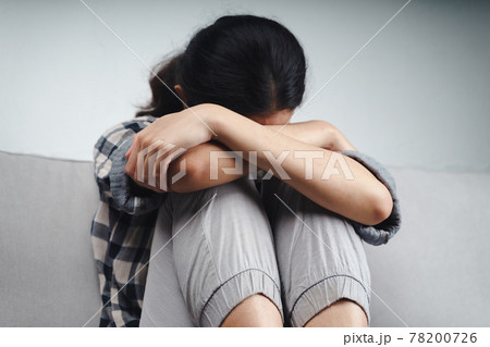 Unhappy lonely depressed woman is sitting on the couch and covering her face with her hands, depression concept Unhappy lonely depressed woman is sitting on the couch and covering her face with her hands, depression concept 78200726