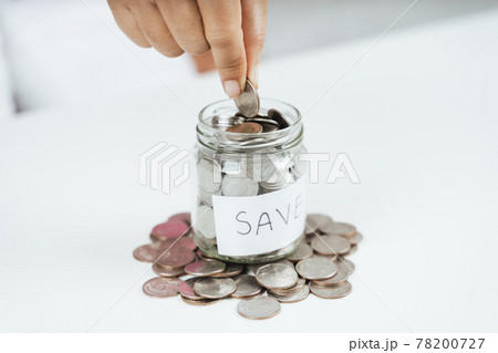 women hand putting money coin into glass jar for saving money. saving money and financial concept women hand putting money coin into glass jar for saving money. saving money and financial concept 78200727