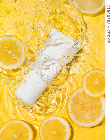 Cosmetic tube in water,lemon slices,yellow bg 78200817