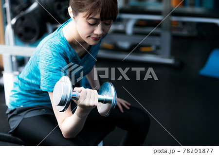 貸し切りのフィットネスジムで筋トレする若い女性 貸し切りのフィットネスジムで筋トレする若い女性 78201877