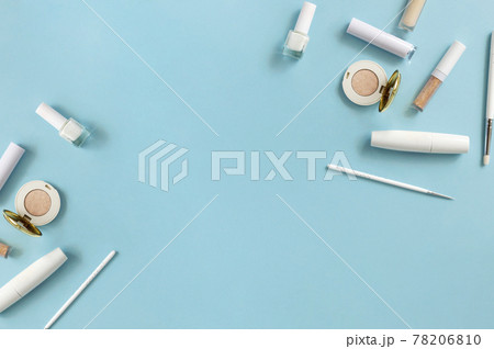 White makeup cosmetics on a blue background with copy space. On the table are shadows, mascara, brushes, lipstick, top view White makeup cosmetics on a blue background with copy space. On the table are shadows, mascara, brushes, lipstick, top view 78206810