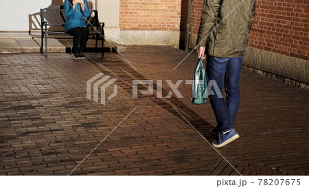 夜の倉敷アイビースクエアの路地裏で待ち合わせをする男女 78207675