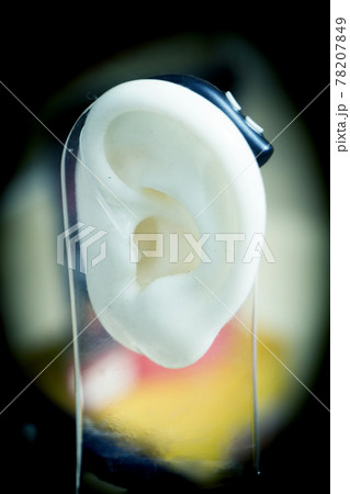Plastic ear with modern hearing aid 78207849