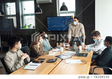Colleagues in masks having meeting in boardroom, businessman making presentation Colleagues in masks having meeting in boardroom, businessman making presentation 78208530
