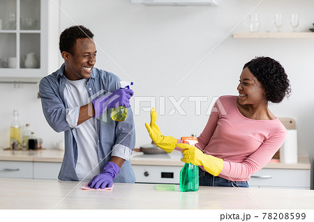 Cheerful black house-keepers having fun while cleaning kitchen 78208599