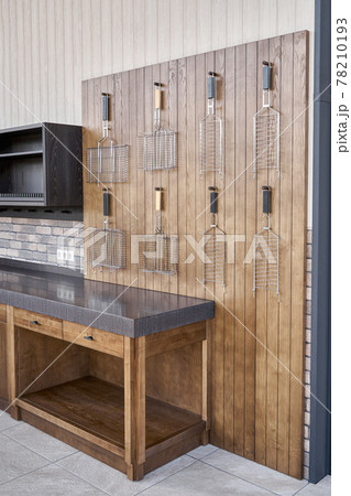 Barbecue grids hang on wainscoting in summer kitchen Barbecue grids hang on wainscoting in summer kitchen 78210193