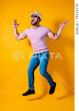 Excited young bearded fitness sporty guy in hat and sunglasses Jump very emotionally isolated on yellow background Excited young bearded fitness sporty guy in hat and sunglasses Jump very emotionally isolated on yellow background 78214176