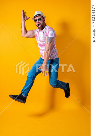 Excited young bearded fitness sporty guy in hat and sunglasses Jump very emotionally isolated on yellow background Excited young bearded fitness sporty guy in hat and sunglasses Jump very emotionally isolated on yellow background 78214177