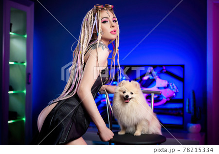 portrait of a sexy woman with dreadlocks in a corset with a cute pomeranian dog portrait of a sexy woman with dreadlocks in a corset with a cute pomeranian dog 78215334