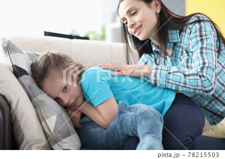 Offended little girl turned away from her mother on couch Offended little girl turned away from her mother on couch 78215503