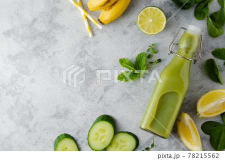 Green smoothie detox drink in glass bottle with fresh spinach, cucumber, banana and lime. Copy space, top view. Green smoothie detox drink in glass bottle with fresh spinach, cucumber, banana and lime. Copy space, top view. 78215562
