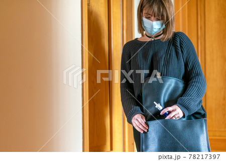 Young woman taking a nasal spray from her bag for protection against coronavirus Young woman taking a nasal spray from her bag for protection against coronavirus 78217397