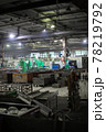 Obsolete unautomated metal processing workshop full of workpieces containers 78219792