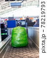 backpack wrapped in green plastic weighed at check-in counter before departure 78219793