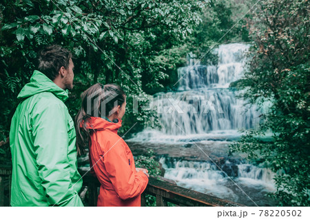 New Zealand tourists at waterfall nature landscape. People looking at Purakaunui Falls, a famous waterfall in the Purakaunui River in the Catlins of the southern South Island of New Zealand 78220502