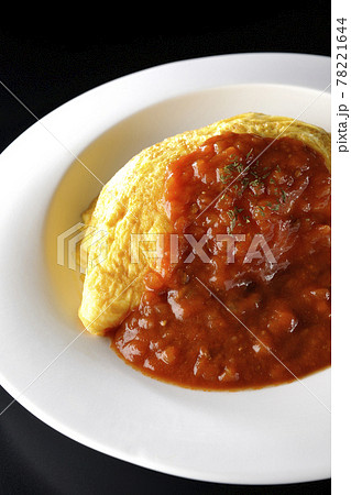 ミートソースのかかったオムライスまたはオムレツを黒背景で撮影 ミートソースのかかったオムライスまたはオムレツを黒背景で撮影 78221644