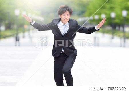 路上でダンスをするスーツ姿の若い男性 78222300