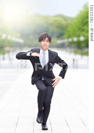 路上でダンスをするスーツ姿の若い男性 78222301