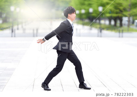 路上でダンスをするスーツ姿の若い男性 78222303