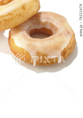 2つの重なったハニーグレーズドーナツを夏っぽい光と白背景で撮影 78222479