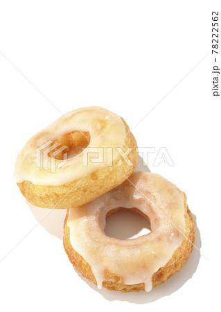 2つの重なったハニーグレーズドーナツを夏っぽい光と白背景で俯瞰撮影 78222562
