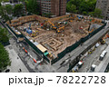 Excavators digging on skyscraper construction site with foundation pit 78222728