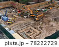 Excavators digging on skyscraper construction site with foundation pit 78222729