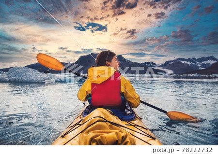 Woman paddle a canoe on an icy bay in Alaska exploring glaciers Woman paddle a canoe on an icy bay in Alaska exploring glaciers 78222732