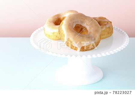 ケーキスタンドに盛り付けられたハニーグレーズドーナツの写真素材