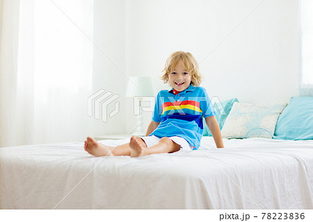 Child playing in bed. Kids room. Baby boy at home. 78223836