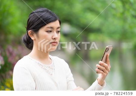 スマホを見て不快な気持ちになって白けている女性 スマホを見て不快な気持ちになって白けている女性 78224559