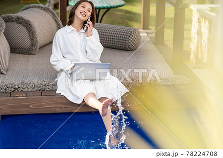 ワーケーション　プールサイド　ビジネスウーマン　スマホ　通話 78224708