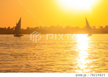 View of the Nile river with sailboats at sunset in Luxor, Egypt View of the Nile river with sailboats at sunset in Luxor, Egypt 78224825