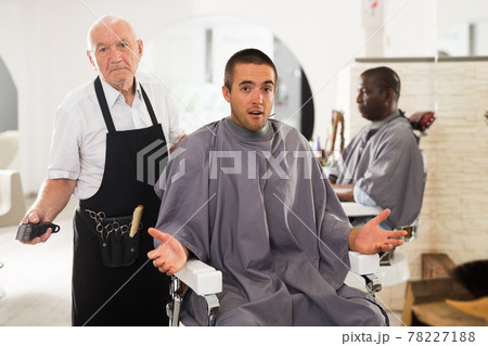 Shocked client with confused aged hairdresser 78227188
