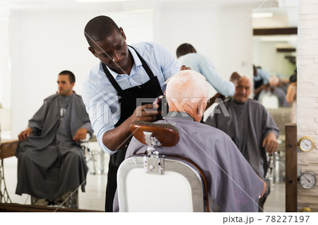 African hairdresser cutting with clipper 78227197