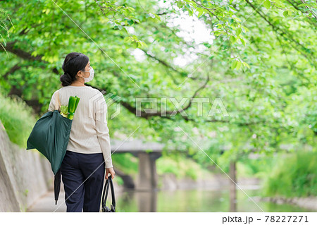 マイバックを持って川岸を歩くビジネスウーマンの後ろ姿 マイバックを持って川岸を歩くビジネスウーマンの後ろ姿 78227271