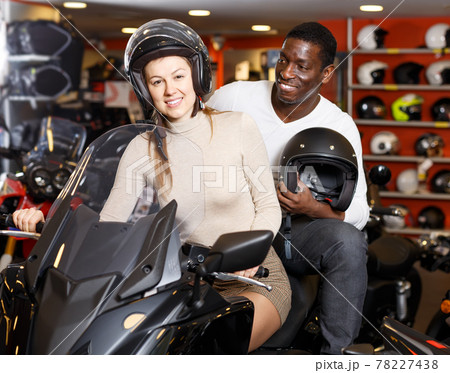 vigorous man and woman posing on new motorcycle in shop vigorous man and woman posing on new motorcycle in shop 78227438