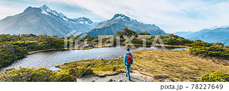New Zealand Hiking. Young hiking man walking on trail at Routeburn Track during sunny day. Hiker tramping Key Summit Track in Fiordland National Park in New Zealand. Panoramic banner New Zealand Hiking. Young hiking man walking on trail at Routeburn Track during sunny day. Hiker tramping Key Summit Track in Fiordland National Park in New Zealand. Panoramic banner 78227649