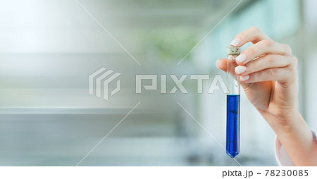 Composition of hand of lab technician holding test tube of blue liquid, with blurred copy space 78230085