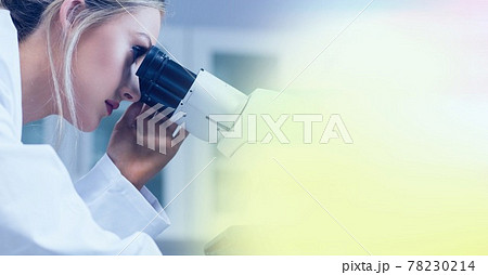 Composition of female lab technician using microscope, with yellow blurred copy space to right 78230214