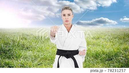 Composition of female martial karate artist with black belt practicing in countryside Composition of female martial karate artist with black belt practicing in countryside 78231257