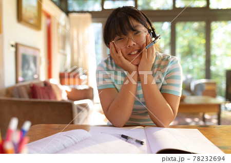 Asian girl wearing phone headset smiling during video call, learning online Asian girl wearing phone headset smiling during video call, learning online 78232694