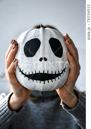 Woman holding Funny pumpkin face in front of her face. Halloween background Diy. Do it yourself. Woman holding Funny pumpkin face in front of her face. Halloween background Diy. Do it yourself. 78234013