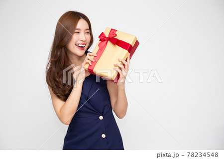 Happy beautiful Asian woman smile with gold gift box isolated on white background. Teenage girls in love, Receiving gifts from lovers. New Year, Christmas and Valentines Day concept 78234548