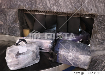 Packed suitcases in protective film on transport tape Packed suitcases in protective film on transport tape 78234980