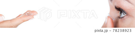 Woman applying contact lens on eye. Long banner 78238923